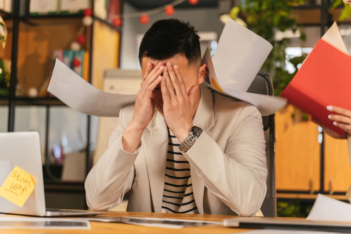 A business owner showing signs of founder dependency at a busy desk