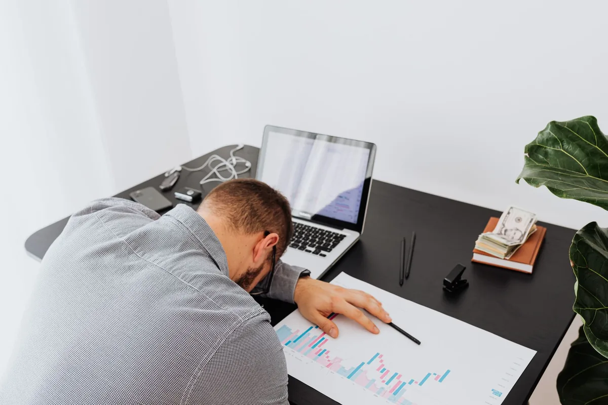 Coach experiencing coaching business burnout at a cluttered desk